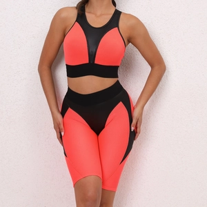 Detail of coral orange honeycomb fabric on two-piece sports bra and yoga shorts set