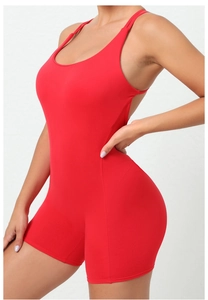 Side view of red backless yoga bodysuit with thin straps and form-fitting athletic shorts