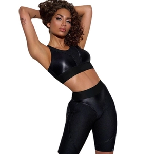 Women's black yoga set with mesh stitching and glossy sports bra with high-waist shorts