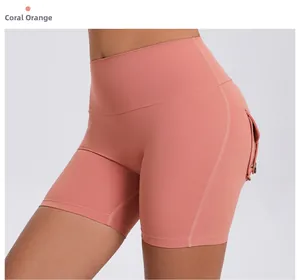 Detail of coral orange high waist yoga shorts with functional cargo side pockets