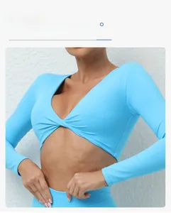 Détail d'un haut de yoga bleu clair à manches longues avec nœud torsadé et col en V