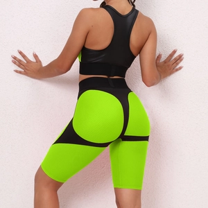 Detail view of honeycomb texture and neon green stitching on black yoga shorts back