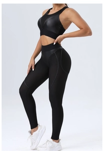 Detail of black yoga set with mesh panels and glossy accents on bra and high waist leggings