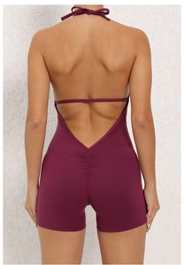 Detail of deep purple halter neck jumpsuit showing backless design and ruched butt lifting seam