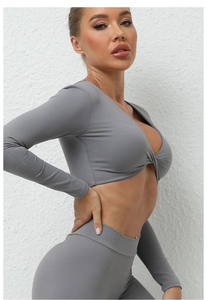 Détail du haut de yoga gris à manches longues avec nœud frontal et tissu extensible