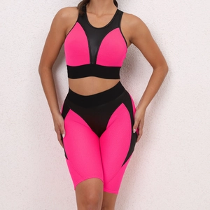 Detail view of pink and black two-piece yoga set with mesh fabric and elastic shorts