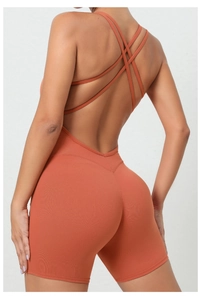 Close-up of cross-back straps on a burnt orange yoga bodysuit for fitness training