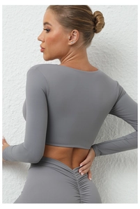 Détail de l'ensemble de yoga gris avec crop top torsadé et legging sculptant taille haute