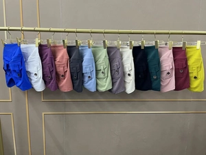 Row of colorful high-waisted cargo yoga shorts with side pockets on golden hangers