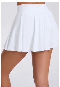 Détail de la jupe de tennis plissée blanche à taille haute en tissu de sport respirant