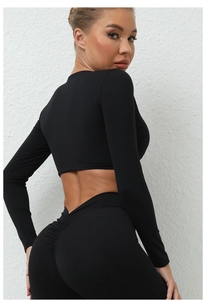 Détail de l'ensemble de yoga noir avec legging froncé et haut court à manches longues