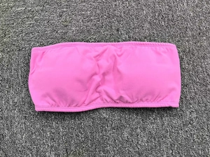 Detailed view of pink strapless sports bra featuring elastic ribbed edges and high stretch fabric