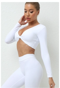 Détail du haut de yoga blanc avec nœud frontal montrant le tissu élastique moulant