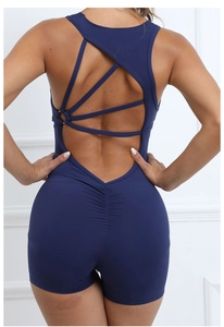 Detail of cross-back straps and ruched butt-lifting design on navy blue yoga jumpsuit