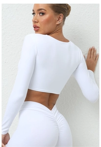 Détail de l'ensemble de yoga blanc avec legging effet push-up et crop top à manches longues