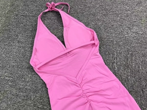 Detail showing pink lace-up halter yoga bodysuit with ruched peach lift design