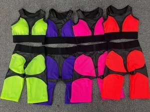 Flat lay of four two-piece yoga sets featuring racerback sports bras and high-waist shorts
