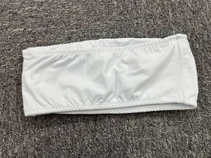 Detailed close-up of white strapless yoga bandeau with elastic ruched hem and knit texture