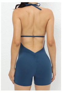 Detail view of backless navy blue yoga jumpsuit showing cross-strap design and ruched detail