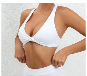 Close-up of white yoga sports bra featuring a twisted front knot and wide straps