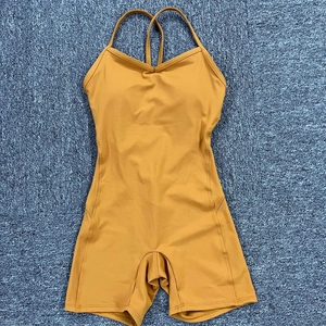Body da yoga giallo con scollo all'americana e imbottiture su un tappeto blu