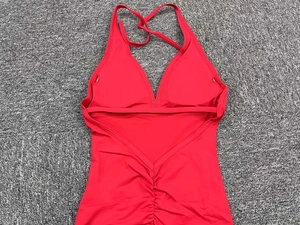 Detail of red halter yoga jumpsuit with ruched peach butt lift effect on fabric
