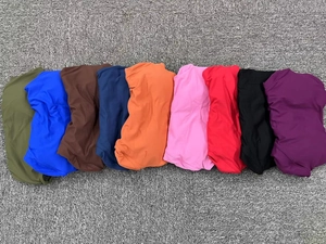 Flat lay detail showing nine vibrant colors of matte seamless yoga jumpsuits on fabric