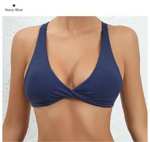 Detail view of navy blue yoga bra featuring deep V-neck and twist knot front design