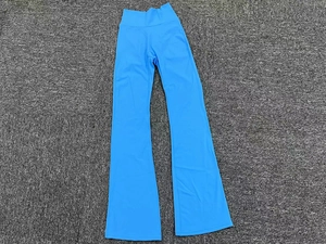Dettaglio dei pantaloni da yoga a zampa blu a vita alta su una superficie ruvida