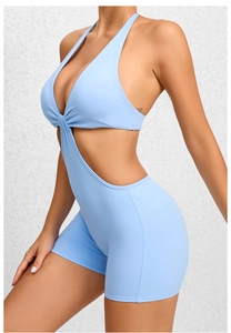 Side view of light blue halter neck yoga bodysuit with waist cutouts and twist detail