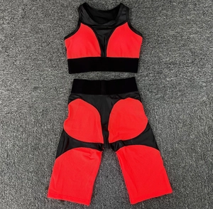 Detail view of red and black two-piece yoga set with mesh fabric on grey carpet