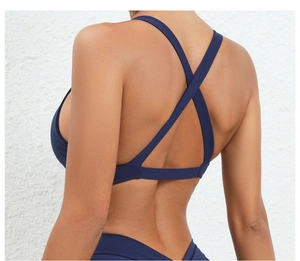 Detail of cross back straps on navy blue yoga sports bra for high support and style