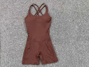 Detail of dark brown backless yoga bodysuit with thin criss-cross straps on carpet