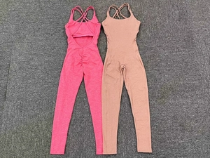 Detail view of pink and brown backless fitness unitards with crisscross straps on a floor