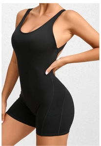 Detail of professional black one-piece yoga romper showing slimming side seam and fabric texture