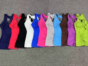 Flat lay of women's racerback sports tops in 11 colors featuring scrunch details and cross straps