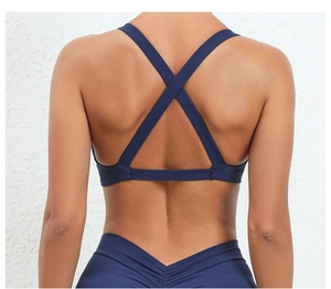 Detail showing cross-back sports bra and V-shaped seam leggings in navy blue