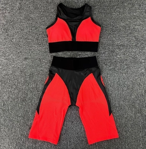 Flat lay of orange and black two-piece yoga set with mesh panels for ventilation