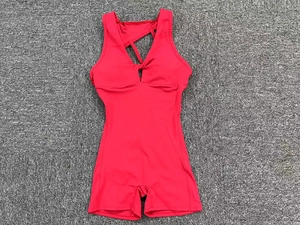 Close-up detail of the bright red v-neck jumpsuit with stylish twist front yoga fabric