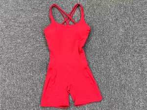 Detail view of red yoga jumpsuit featuring double criss-cross back straps and flat shorts