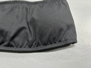 Detail of high-density elastic fabric with durable double-stitched flat seam on a black yoga bra