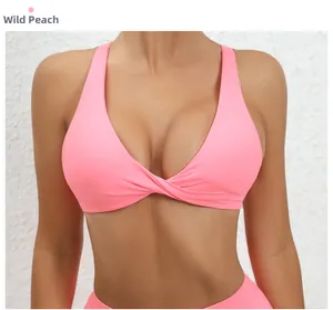 Detail of wild peach sports bra featuring a center twist knot and halter-style back
