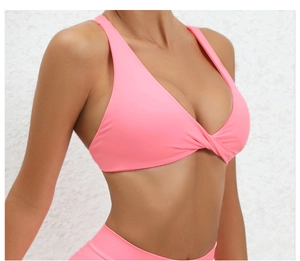 Detail of hot pink yoga bra featuring a stylish front twist knot and wide straps design