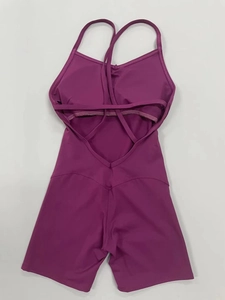 Dettaglio del design con spalline incrociate sulla schiena di una tuta fitness viola