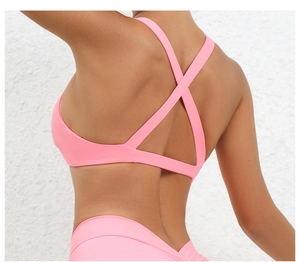 Detail shot of pink sports bra featuring criss-cross back straps and elastic fabric