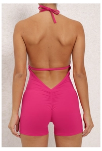 Detail of ruched peach butt seam and open back design on rose red yoga bodysuit