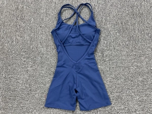Detail of navy blue yoga romper featuring cross straps and V-shaped open back design