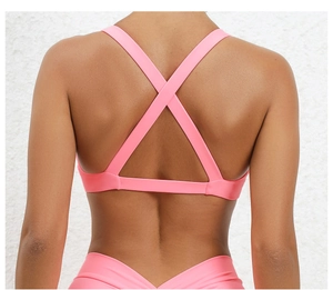 Pink sports bra with criss-cross back straps and matte moisture-wicking fabric