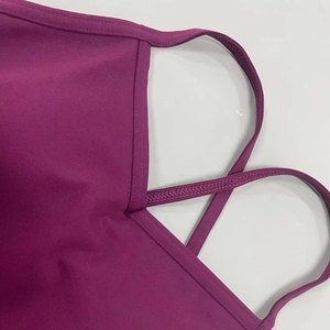 Dettaglio del body da yoga viola con spalline incrociate e cuciture rinforzate a punto Z