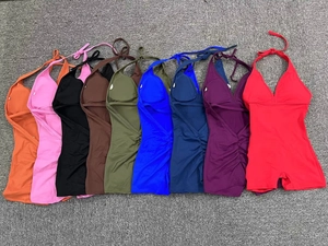 Flat lay of ribbed halter yoga jumpsuits in nine colors including pink and navy blue